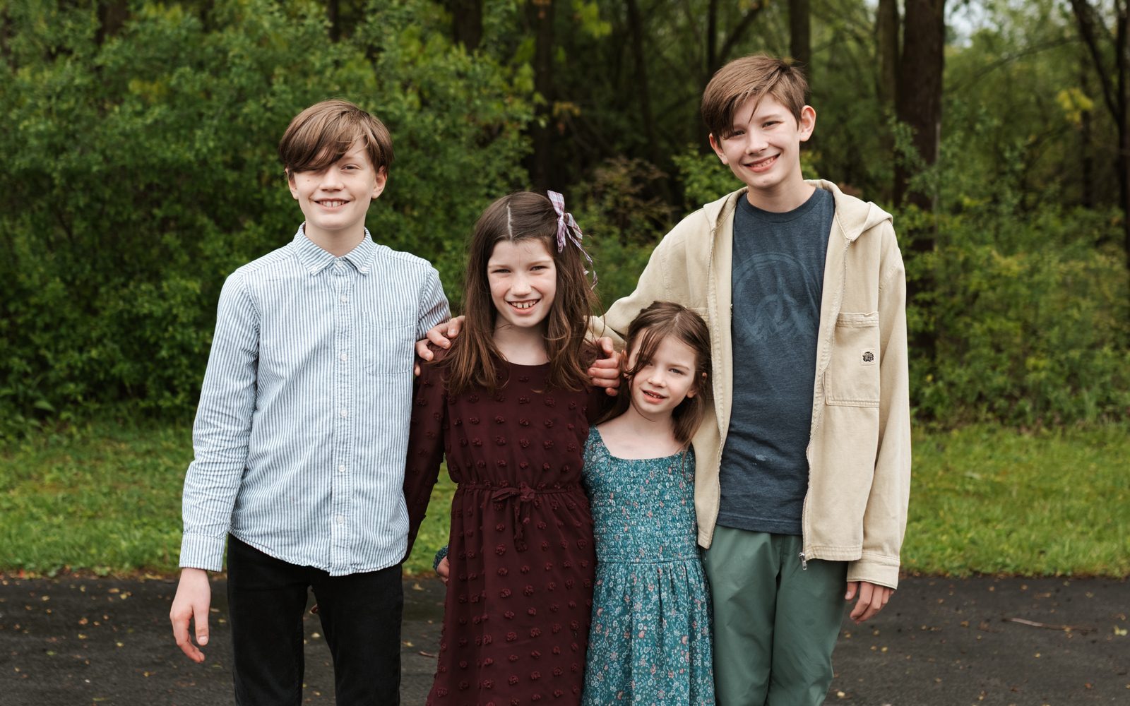 Four children and teens standing together outside United With Christ Church, Auburn